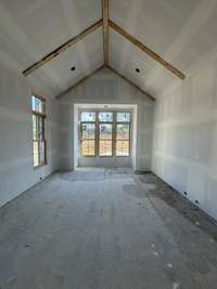 Primary Bedroom on Main Level with beam detail and ensuite bath with oversized walk-in closet. *this home is under construction Photo taken 9/5/24