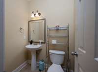 Powder room tucked discretely off foyer.