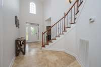 Foyer from living room, looking towards front door and primary bedroom.