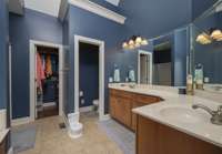 Primary bathroom separate sinks and counters, separate water closet and clothes closet.