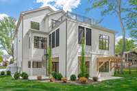 View of all three outdoor living spaces. Top deck, screened outdoor iving space on main level and open pation on lower level with 2 separate side patios.