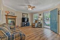 The living room has lots of natural light, a ceiling fan, and a fireplace