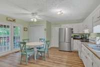 The kitchen boasts bright white cabinetry for ample storage and stainless fridge (can remain with home)