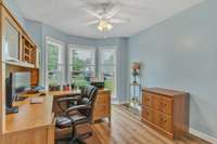 Second bedroom on main level with bay window and ceiling fan