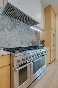 Fisher & Paykel stainless steel appliances - 8 burner gas range, double ovens, hidden fridge