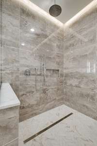 Large shower area w/double shower heads + shelf