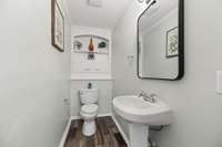 The half bathroom still has the original built-ins above the toilet and the cute pedestal sink.