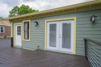 Backyard deck leading separately to laundry room and primary bedroom