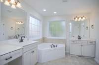 Separate Vanities and large soaking tub in the primary suite bathroom.