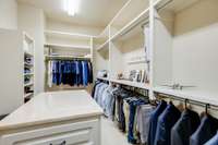 A spacious walk- in closet  with island dresser provides ample space for organizing all your clothing essentials.