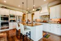 Indulge your culinary passion in this dream kitchen featuring stainless steel appliances, a convenient warming drawer, and custom tiled backsplash. New lighting, painted cabinets  complete with pull out drawers.