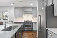 Stainless Steel Appliances: Gas Cooktop, Bertazzoni Oven, Refrigerator, & Dishwasher, Bianca Perla Honed Marble Countertops, Spacious Pantry, & Oversized Island.