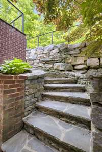 This dreamy stone path takes you from the walk-out basement apartment to the upper outdoor living area