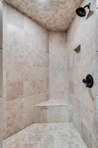 Walk in fully tiled shower with tile floors in bathroom to match