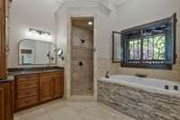 Master bath with custom cabinetry, full jetted jacuzzi bathtub that stays warm even when the water isn't running...and Castle Entry wrought iron window.