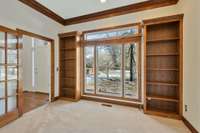 Beautiful office with wood paneled tray ceilings and built in bookshelves to immediate left when you come in front door.