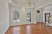 Dining room with tray ceiling, chair molding, fun chandelier, and tons of light.