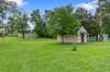 The backyard showcases a lovely flat lot, complemented by a practical shed.