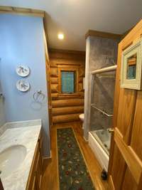 Primary bath with marble tiled shower, glass doors, and linen closet