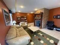 Downstairs mother-in-law suite den/living room.  The large Buck Stove can help keep the whole house heated during cold months.