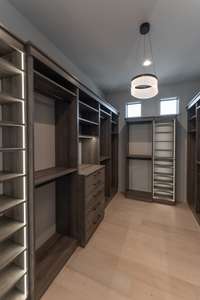 huge walk in closet with backlit shelving