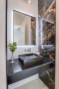 Main level 1/2 bath with floating vanity and backlit mirror.