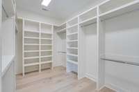 large custom primary closet with lots of storage.