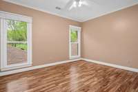 The crisp angles of the final upper-level bedroom are highlighted by the freshly painted, offering character and charm to the space. The massive, energy efficient windows here and throughout the home were installed in 2013 for enhanced value.