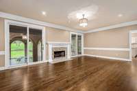 Beautiful glass doors flank the fireplace in the living room, offering views to the decadent outdoor living areas from the comfort of your seat. Easily accessible, and just steps from the kitchen, this central space is the heart of your new home.