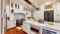 Kitchen Island boasts stunning marble countertops, built in microwave and wine refrigerator