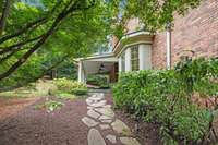 The path from the parking area leads to the inviting covered back porch, offering a journey of tranquility and anticipation.