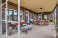 Spacious Covered Back Porch w access to Den and Primary Bedroom a Perfect Place to Relax and Enjoy the Peaceful Outdoor Setting