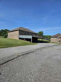 Paved driveway leads to your covered carport. Carport runs the length of the home and can fit three cars if needed.