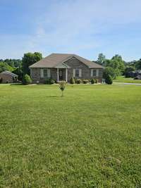 Home sits back off of the road with a spacious front yard.