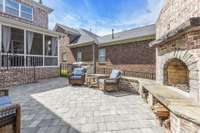 Lovely patio space features paver stone patio, built-in brick fireplace with gas starter and wood storage.