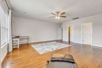 Wood flooring, accent wall and ceiling fan make this space work so well for however you choose.