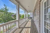 Upper porch area with swing and ceiling fans