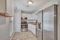 Kitchen includes stainless steel appliances, tile flooring & pantry