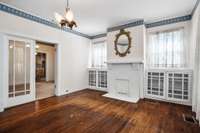 living room fireplace with metal fireplace screen and vintage lighting