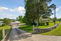 rock wall entry and concrete drive leading to garage