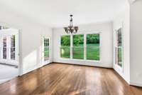 This is the breakfast room with hardwoos foors and door to the patio.