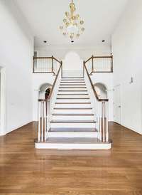 Come inside and you are greeted with this sweeping elegant staircase in the two-story foyer.