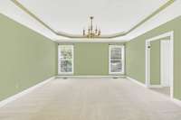 Let's take a look at the primary bedroodm on the main level.  This huge room has a tray ceiling and brand new carpet.