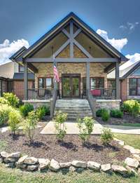 The stately front porch and warm stone and brick exterior draws you in immediately and you know you are in for something special.