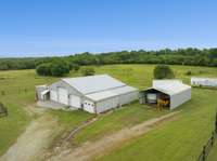 5 bay garage with work shop, paint room, and 2 other finished spaces.  All heated and cooled.  Equipment carport to remain.  One of the 50' trailers to remain for hay storage.