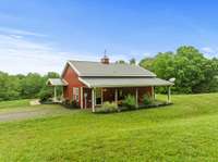 The back side of the barndominium covered porch overlooks the main farmhouse.