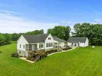 Back view of the farmhouse. The entrance to the basement is the exterior door on the left side of the house.