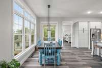 Beyond the dining room, the double glass exterior doors open into the screened-in porch, which overlooks the backyard.