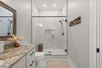 Tiled walk-in shower with glass doors.