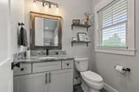 A half bathroom overlooking the front yard is just off the second living area. It has marble countertops and a comfort-height toilet.